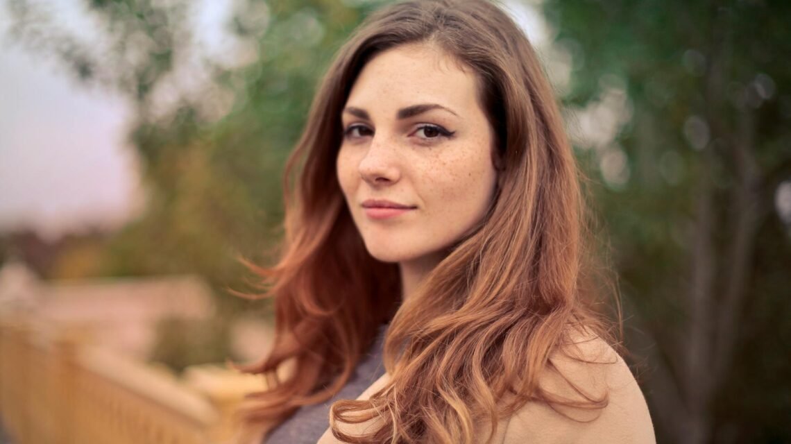 closeup photo of woman with brown coat and gray top