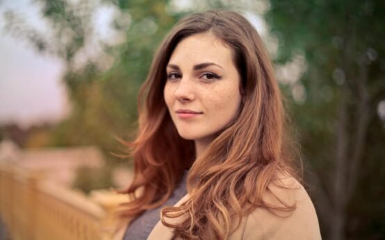 closeup photo of woman with brown coat and gray top