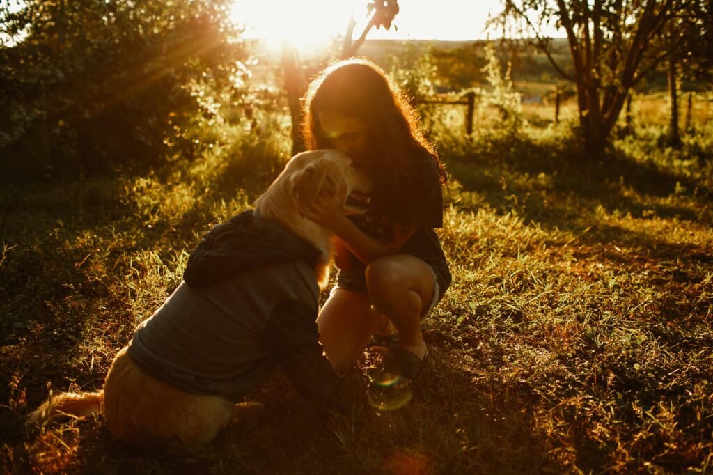 woman kissing dog in field