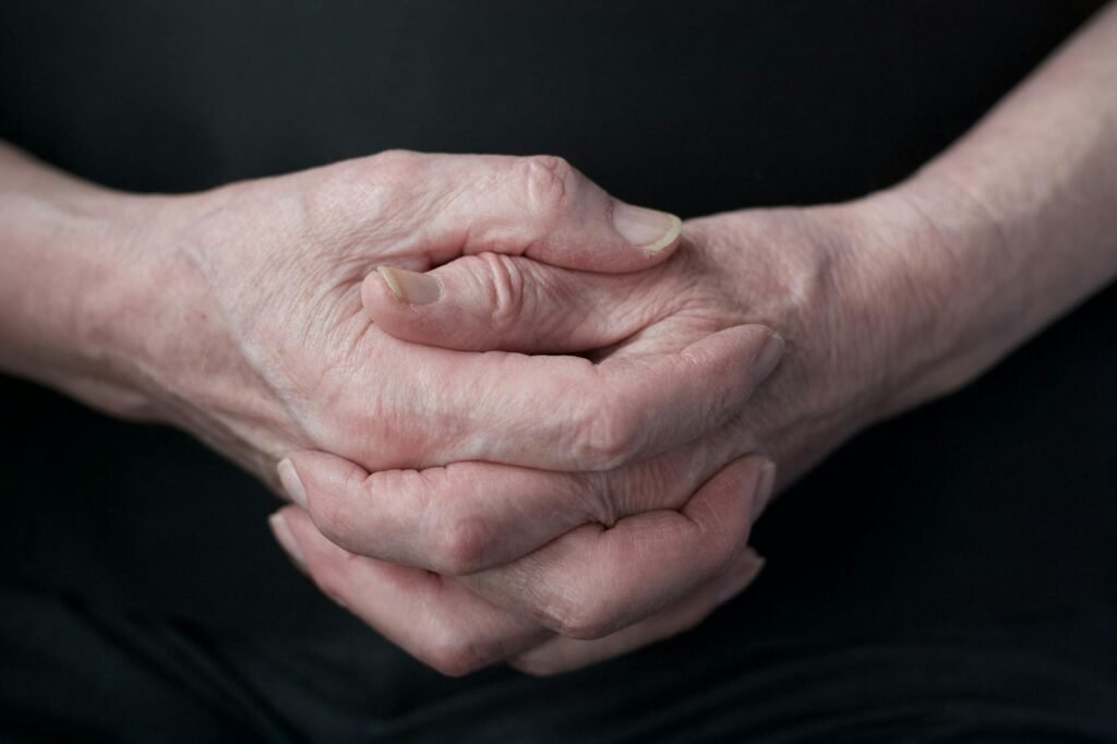elderly hands clasped in deep thought