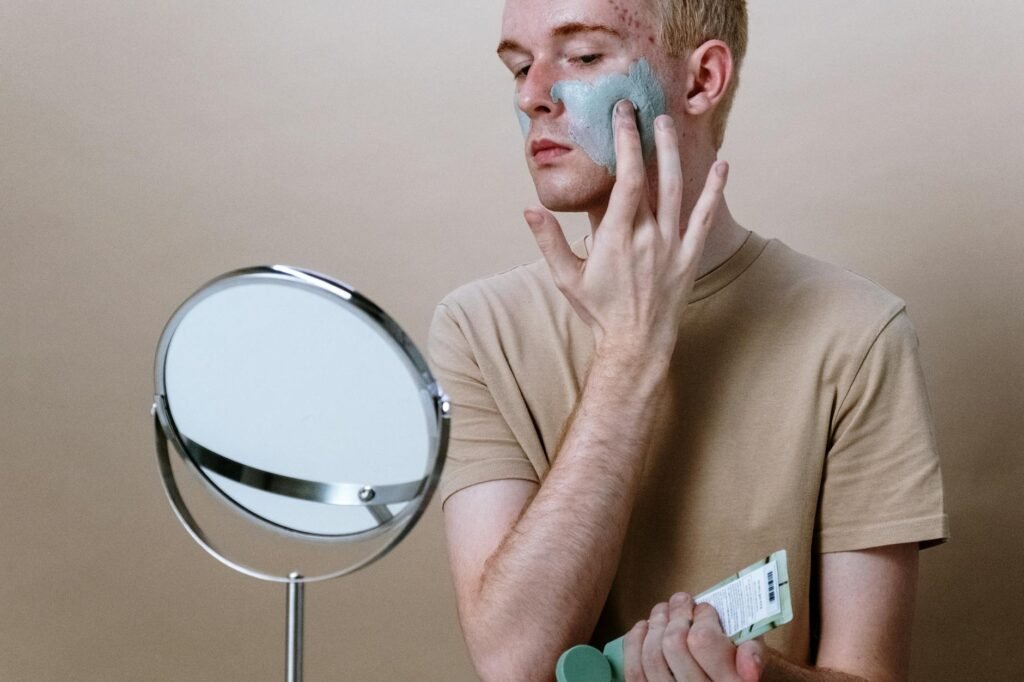 man in brown crew neck t shirt holding round mirror
