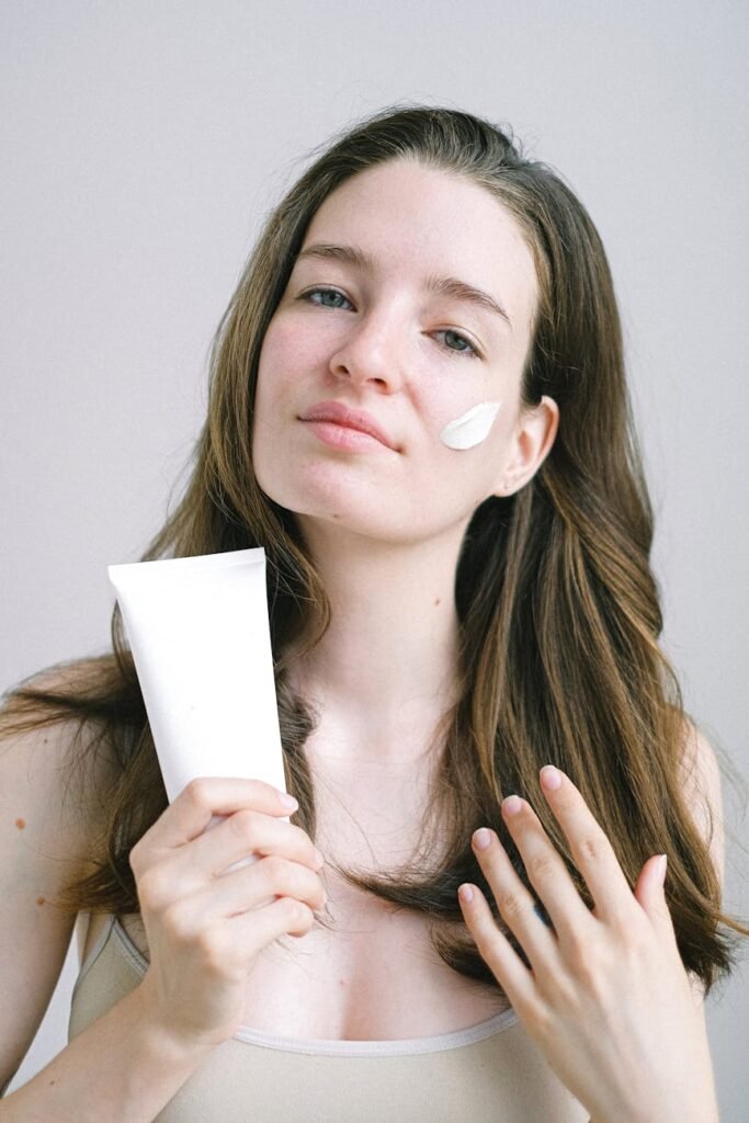 young woman presenting cosmetic product with white swear on face