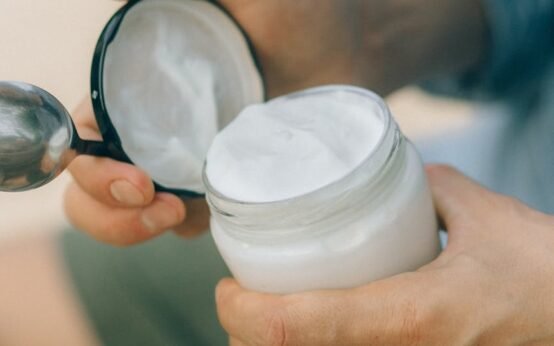 person holding white round container