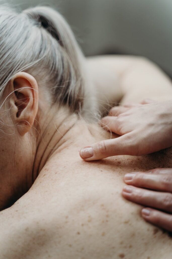 a topless woman having a shoulder massage