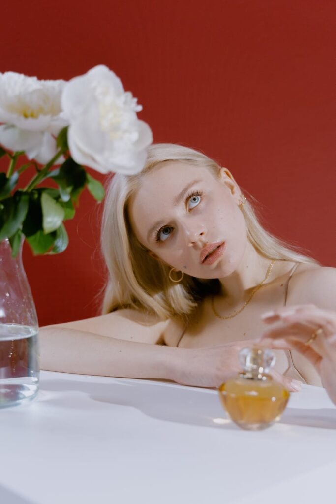 woman in white floral dress sitting beside table with clear drinking glass