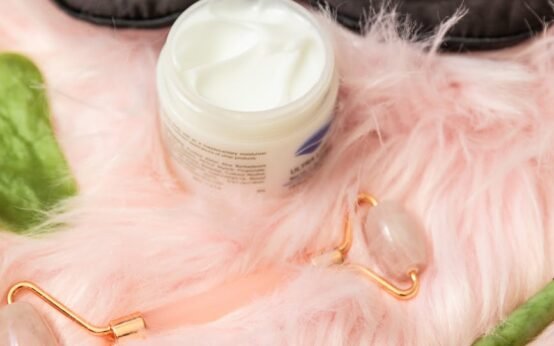 jade rollers and facial cream beside an eye mask