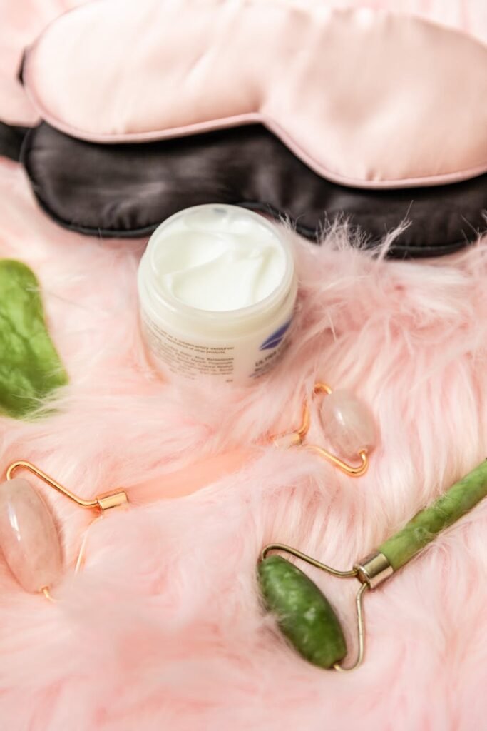 jade rollers and facial cream beside an eye mask